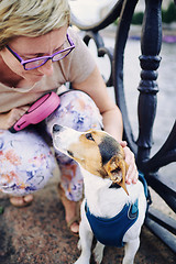 Image showing Senior woman petting dog on embankment