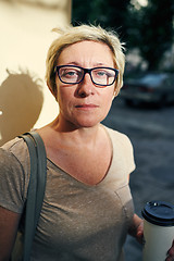 Image showing Senior woman with beverage looking at camera