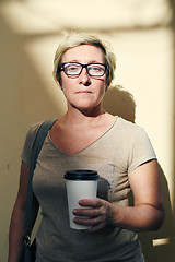 Image showing Senior woman with beverage looking at camera