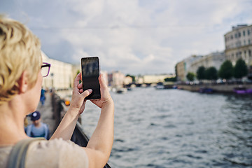 Image showing Anonymous woman taking picture on embankment