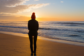 Image showing Watching the sunrise from sandy seashore in winter