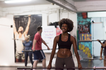 Image showing black woman lifting empty bar