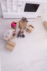 Image showing woman with many cardboard boxes sitting on floor