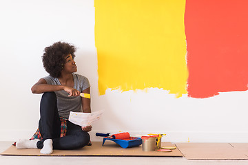 Image showing back female painter sitting on floor