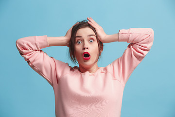 Image showing Beautiful woman looking suprised isolated on blue