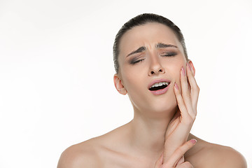 Image showing Closeup portrait of young woman suffering from terrible tooth pain, touching pressing her cheek. Dental care and toothache.