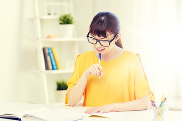 Image showing happy asian young woman student learning at home