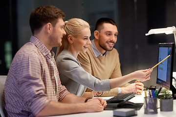 Image showing business team with computer working late at office