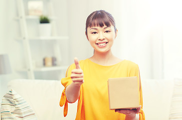 Image showing happy asian young woman with parcel box at home