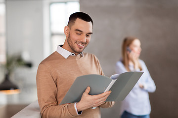 Image showing smiling male office worker with folder