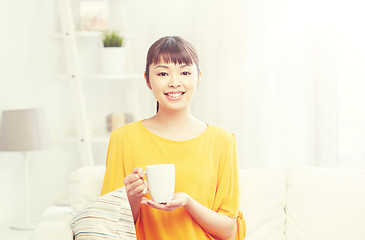 Image showing happy asian woman drinking from tea cup