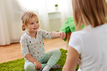 Image showing girls playing rock-paper-scissors game at home