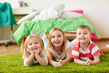 Image showing happy little kids lying on floor or carpet