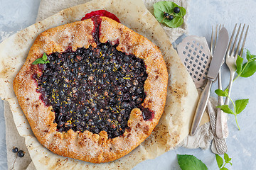 Image showing Pie(Galette) with black currant and lemon zest.