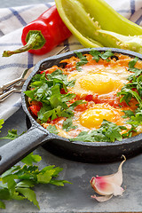 Image showing Shakshuka. Frying pan with eggs in tomato sauce.