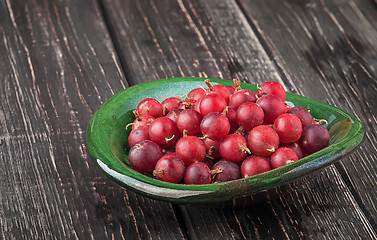 Image showing Red gooseberry in clay bowl