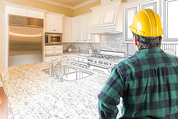 Image showing Male Contractor with Hard Hat Looking At Custom Kitchen Drawing 