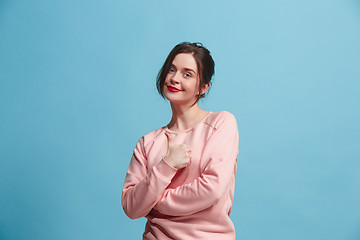 Image showing The happy business woman standing and smiling against pastel background.