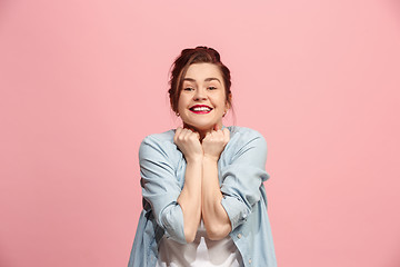 Image showing The happy business woman standing and smiling against pink background.