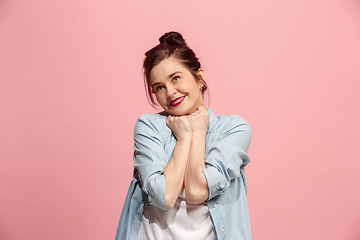 Image showing The happy business woman standing and smiling against pink background.