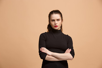 Image showing The serious business woman standing and looking at camera against pastel background.