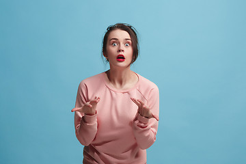 Image showing Beautiful woman looking suprised isolated on blue