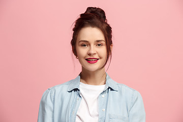 Image showing The happy business woman standing and smiling against pink background.