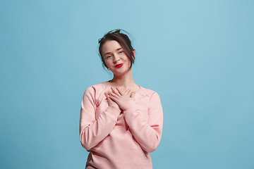 Image showing The happy business woman standing and smiling against blue background.