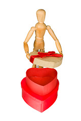 Image showing Wooden mannequin opens heart shaped gift box