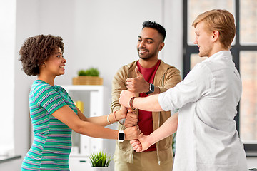 Image showing happy creative team making high five at office