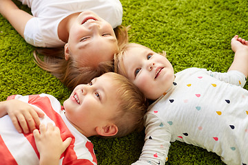 Image showing happy little kids lying on floor or carpet