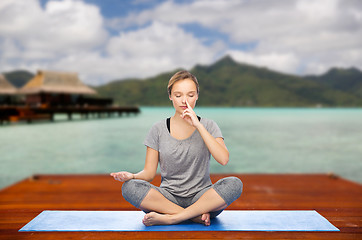 Image showing woman making yoga in and meditating lotus pose