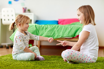 Image showing girls playing rock-paper-scissors game at home