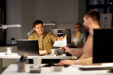 Image showing coworkers with papers working at nigh office