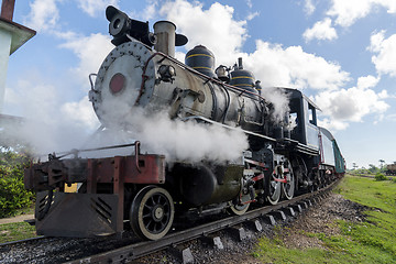 Image showing Old steam locomotive or railway train arriving to the platform 