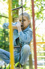 Image showing The girl pondered climbed the hanging ladder in the playground