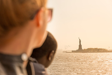 Image showing Tourists looking at Statue of Liberty silhouette in sunset from the staten island ferry, New York City, USA