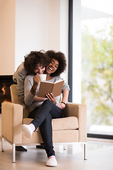 Image showing multiethnic couple hugging in front of fireplace