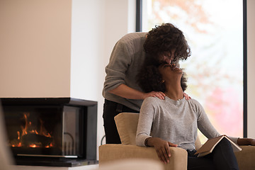 Image showing multiethnic couple hugging in front of fireplace