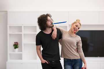 Image showing couple in party hats blowing in whistle