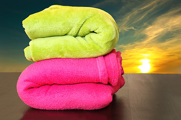 Image showing colorful towels prepared for sunset bath in the sea