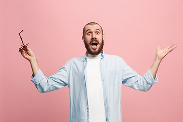 Image showing The young attractive man looking suprised isolated on pink