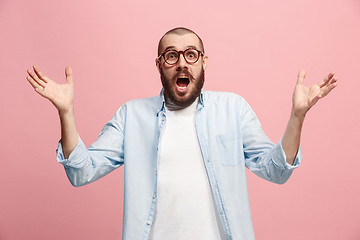 Image showing The young attractive man looking suprised isolated on pink