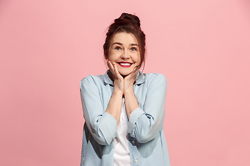 Image showing The happy business woman standing and smiling against pink background.