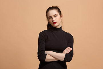 Image showing The serious business woman standing and looking at camera against pastel background.