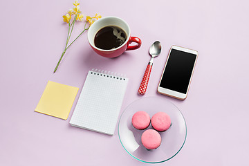 Image showing The top view on female desk. The phone and french macarons on trendy pink desk.