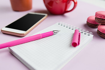 Image showing The side view on female desk. The phone and french macarons on trendy pink desk.