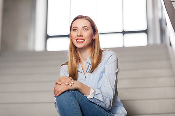 Image showing happy smiling woman or student sitting on stairs