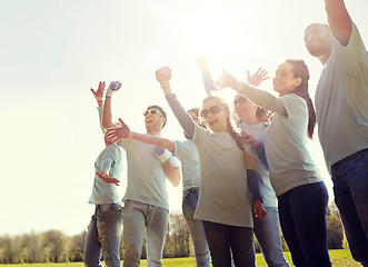 Image showing group of volunteers celebrating success in park