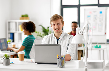 Image showing creative male office worker with laptop